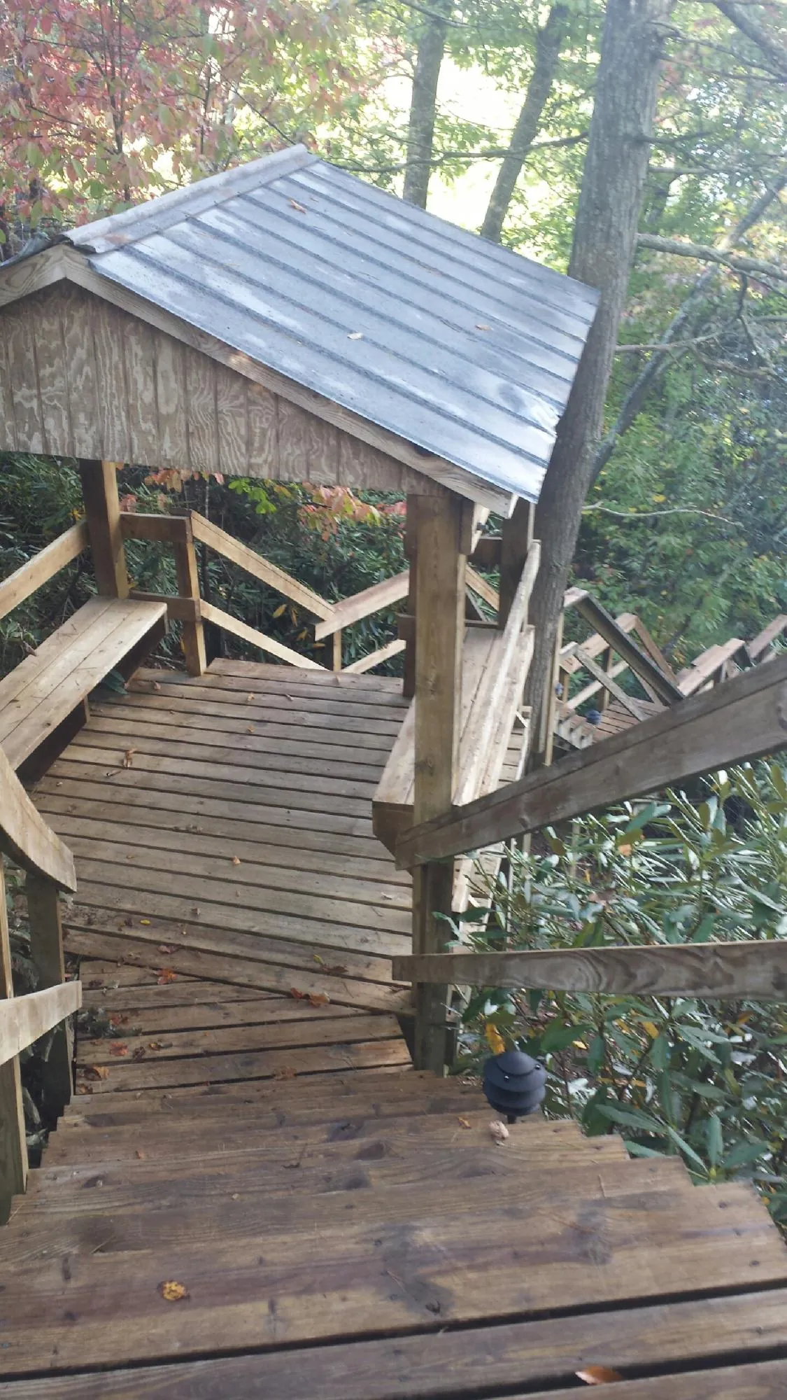 Metal roofed shelter over wooden steps on a wooded walkway — Skylight Repair & Installation work by our crew in What Cheer